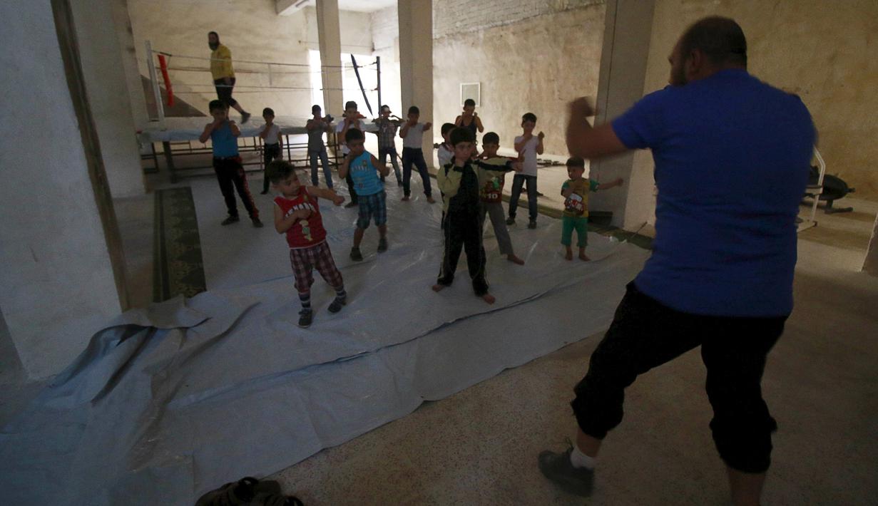 Seorang pria melatih anak-anak bertinju di Free Sports Federation, Old Aleppo, Suriah. (19/102015). (Reuters/Hosam Katan)