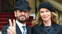 Ringo Starr berpose dengan istrinya Barbara Bach saat tiba untuk menerima gelar kebangsawanan dari kerajaan Inggris di Istana Buckingham, di London (20/3). Ringgo diberi gelar 'Sir' atas jasanya dalam dunia musik. (John Stillwell / Pool Photo via AP)