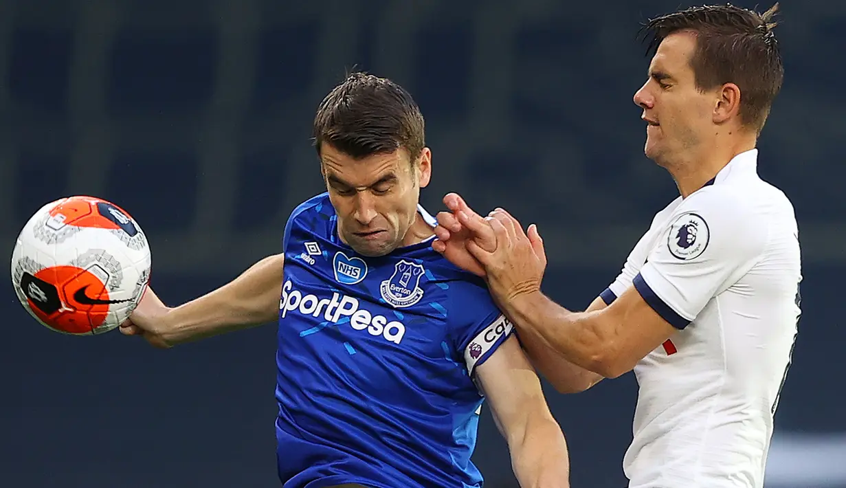 Gelandang Tottenham Hotspur, Giovani Lo Celso, berebut bola dengan bek Everton, Seamus Coleman, pada laga lanjutan Premier League di Tottenham Stadium, Selasa (7/7/2020) dini hari WIB. Tottenham menang 1-0 atas Everton. (AFP/Richard Heathcote/pool)