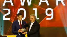 Bek berdarah Maroko, Achraf Hakimi menerima penghargaan Pemain Muda Terbaik Afrika 2019 pada acara CAF Awards di kota wisata Mesir, Hurghada, Selasa (7/1/2020). Selain Pemain Muda Terbaik Afrika 2019, acara itu juga mengumumkan beberapa penghargaan bergengsi lainnya.  (Khaled DESOUKI/AFP)
