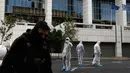 Petugas kepolisian mencari barang bukti usai ledakan bom di Pengadilan Banding di Athena, Jumat, (22/12). Polisi Yunani melaporkan tidak ada korban jiwa akibat kejadian tersebut. (AP Photo / Thanassis Stavrakis)