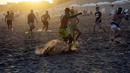 Para pria bermain sepak bola di pantai di tengah gelombang panas musim panas di Carilo, provinsi Buenos Aires, Argentina (14/1/2022). Argentina menghadapi gelombang panas paling ekstrem dalam sejarah dengan suhu yang melonjak di atas 40 derajat celcius. (AP Photo/Rodrigo Abd)