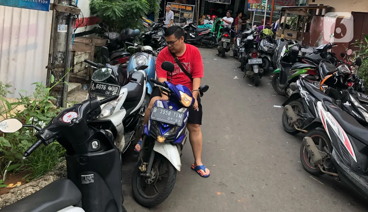 Warga parkir di sekitar Jalan Kebon Pala II, Jakarta, Selasa (25/2/2020). Banjir yang merendam kawasan tersebut menyebabkan warga mengungsikan kendaraannya ke tempat yang lebih tinggi. (Liputan6.com/Immanuel Antonius)