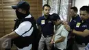 Petugas menggiring tersangka pelaku ledakan di Mall Alam Sutera berinisial LWK saat konferensi pers di Polda Metro Jaya, Jakarta, Kamis (29/10). LWK yang merupakan staf IT diduga melakukan pengebomannya atas dasar pemerasan. (Liputan6.com/Yoppy Renato)