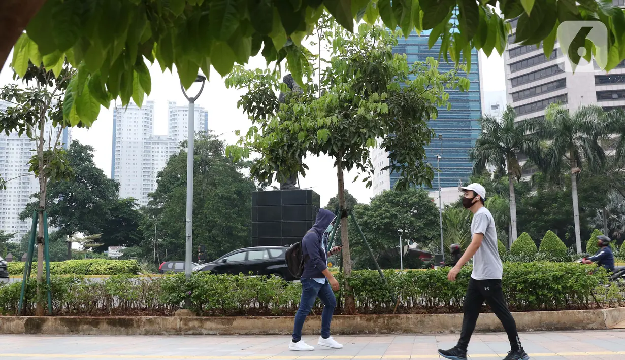 Warga mengenakan masker berjalan di pedestrian Jalan Jenderal Sudirman, Jakarta, Kamis (5/11/2020). BPS mencatat ekonomi Indonesia pada kuartal III-2020 minus 3,49 persen, Indonesia dipastikan resesi karena pertumbuhan ekonomi dua kali mengalami minus. (Liputan6.com/Helmi Fithriansyah)