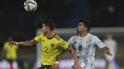 Bek timnas Kolombia, Stefan Medina dan gelandang Kolombia, Argentina Marcos Acuna mengawasi bola pada laga lanjutan Kualifikasi Piala Dunia 2022 Zona Amerika Selatan di Stadion Metropolitano, Rabu (9/6/2021) pagi WIB. Argentina bermain imbang 2-2 dengan Kolombia. (AP Photo/Fernando Vergara)