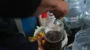 Pengurus RW 01 menampung hasil pengolahan sampah plastik yang telah mencair menjadi bahan bakar alternatif atau petasol di Jakarta, Senin (19/10/2026). (KLY/Budy Santoso)