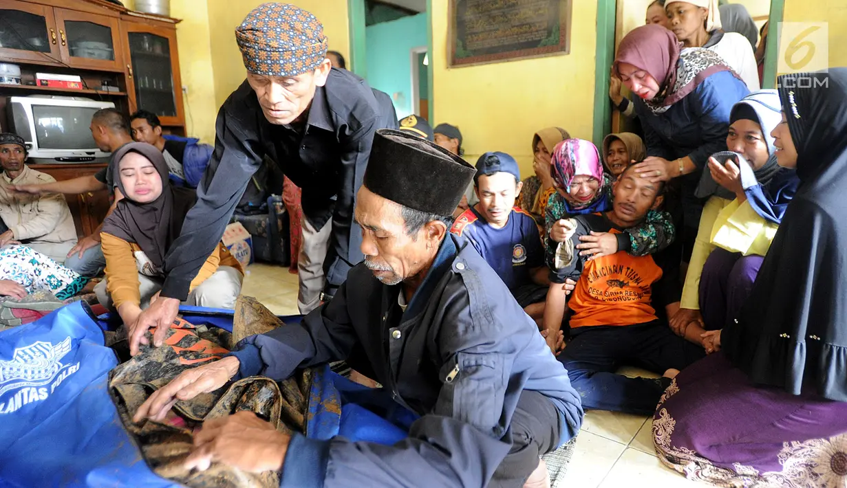Keluarga histeris melihat jenazah korban longsor di Dusun Cimapag, Desa Sirnaresmi, Kecamatan Cisolok, Sukabumi, Selasa (1/1). Longsor mengakibatkan 30 rumah yang dihuni 107 jiwa tertimbun. (merdeka.com/Arie Basuki)