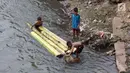 Anak-anak bersiap berenang menggunakan batang pohon pisang di bantaran Sungai Ciliwung, Jakarta, Selasa (15/5). Aktivitas tersebut berbahaya bagi kesehatan dan keselamatan mereka. (Liputan6.com/Immanuel Antonius)
