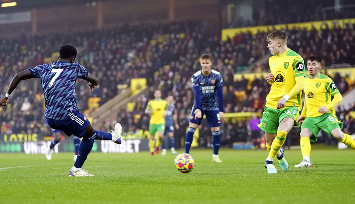 Pemain Arsenal Bukayo Saka (kiri) mencetak gol ke gawang Norwich City pada pertandingan sepak bola Liga Inggris di Stadion Carrow, Norwich, Inggris, Minggu (26/12/2021). Arsenal menang 5-0. (Joe Giddens/PA via AP)