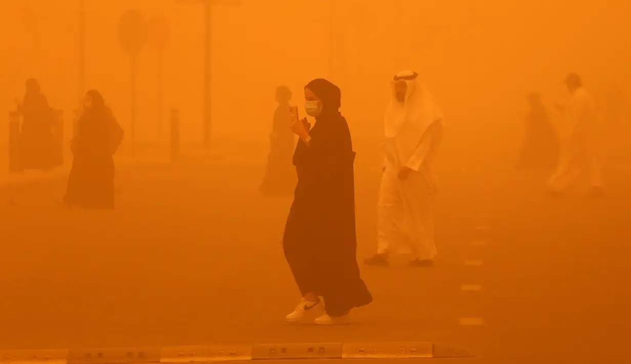 <p>Pejalan kaki menyeberang jalan di tengah badai debu parah di Kota Kuwait pada 23 Mei 2022. Badai pasir telah melanda Timur Tengah dalam beberapa hari terakhir, dan menjadi fenomena yang para ahli peringatkan dapat berkembang luas karena perubahan iklim. (Yasser Al-Zayyat / AFP)</p>
