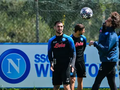 Pemain depan Napoli Matteo Politano (Tengah) dan pemain belakang Napoli Mario Rui (kanan) ambil bagian dalam sesi latihan jelang melawan AC Milan pada leg pertama babak perempat final Liga Champions 2022/2023, di pusat latihan klub di Castel Volturno, Selasa (11/4/2023). (Photo by Filippo MONTEFORTE / AFP)