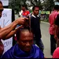 Para aktivis mencukur rambut sampai gundul sebagai bentuk syukur setelah KPK menangkap dan menahan Bupati Batubara, Sumatera Utara, OK Arya Zulkarnaen. (Liputan6.com/Reza Efendi)