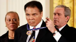 Mantan Presiden AS George W. Bush (kanan) saat memberikan penghargaan kepada Muhammad Ali di gedung putih,Washington, 9 November 2005. Muhammad Ali meninggal karena penyakit komplikasi pernapasan sejak Kamis lalu. (REUTERS / Kevin Lamarque)