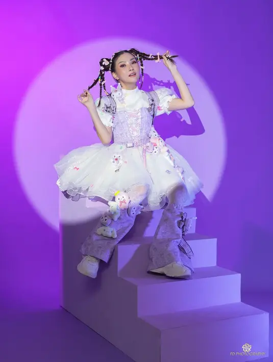 Sarwendah sendiri kenakan gaun putih satin dengan lengan balon dan rok tulle. Korset kepang dan aksen bunga di kaki bikin Sarwendah tampil playful [@fdphotography90]