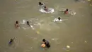 Anak-anak mencari koin saat umat Hindu mencelupkan bibit jelai sebagai persembahan saat Festival Navratri di Sungai Tawi, Jammu, India, 10 April 2022. Sesaji tersebut dibuat sebagai bagian dari ritual menandai berakhirnya festival selama sembilan hari. (AP Photo/Channi Anand)