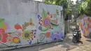 Pengendara motor melintasi gang sempit yang sisi tembok dindingnya dihiasi lukisan mural warna-warni di Kampung Pejaten, Jakarta, Senin (30/4). Mural motif warna-warni itu digagas warga untuk memperindah kampung mereka. (Liputan6.com/Herman Zakharia)
