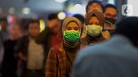 Calon penumpang kereta api mengenakan masker saat berada di Stasiun Gambir, Jakarta Pusat, Jumat (31/01). Dalam rangka pencegahan Virus Corona, PT Kereta Api Indonesia (persero) melakukan sosialisasi kepada penumpang dengan membagi-bagikan masker di stasiun Gambir. (merdeka.com/Imam Buhori)