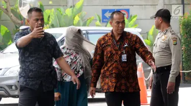 Kasi Dinkes Bengkulu Selatan Wati mendapat pengawalan petugas saat tiba di Gedung KPK, Jakarta, Rabu (16/5). Wati terjaring dalam OTT di rumah pribadi Bupati Bengkulu Selatan Dirwan Mahmud. (Merdeka.com/Dwi Narwoko)