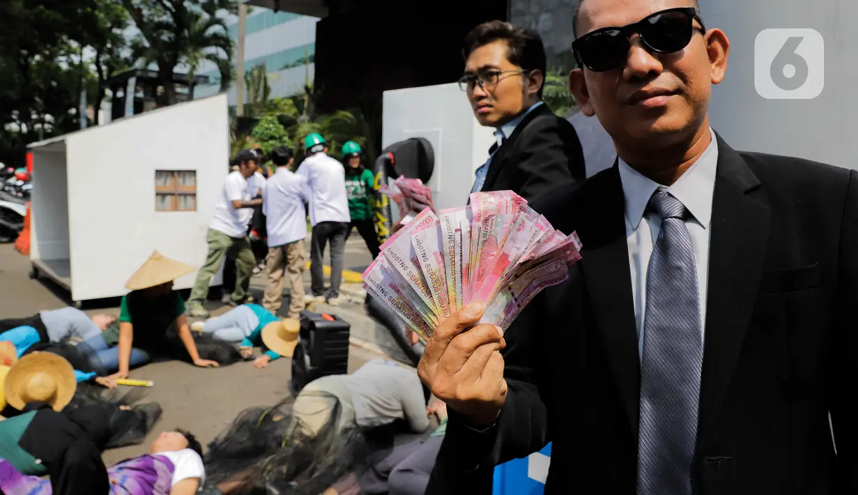 Koalisi melakukan teatrikal, yang menggambarkan sejumlah pejabat tengah merauk batu bara, dengan asap menggumpal yang menyebabkan beberapa masyarakat pingsan, hingga terkena ISPA akibat PLTU. (Liputan6.com/Herman Zakharia)