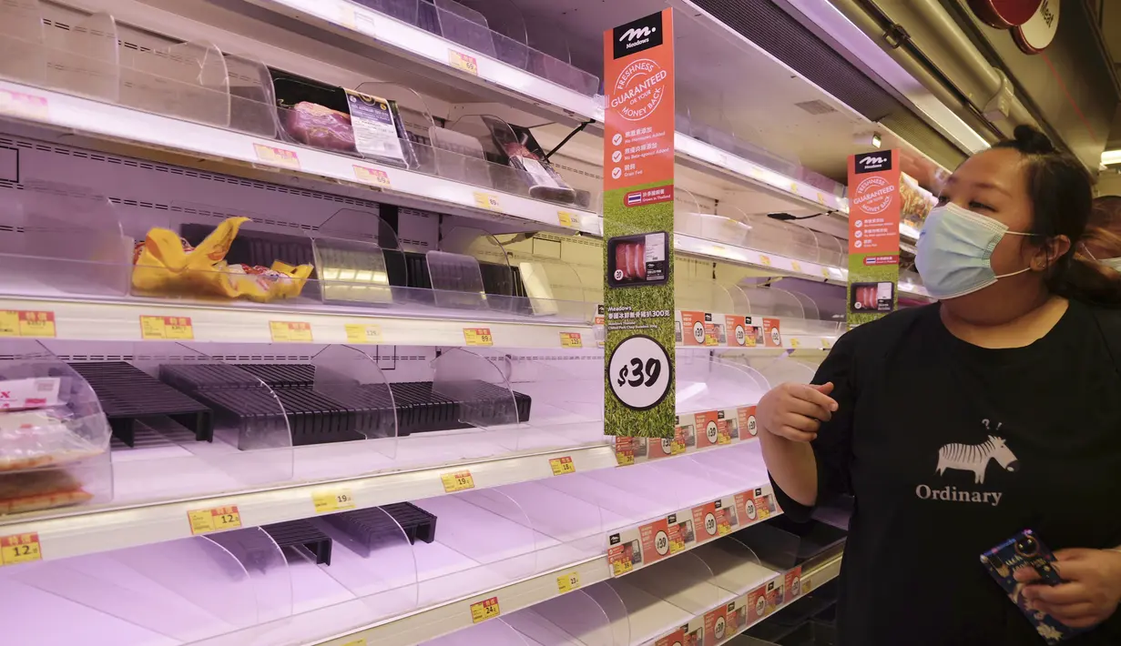 Pengunjung melihat rak-rak kosong di supermarket saat berbelanja makanan untuk persiapan menghadapi Badai Kompasu di Hong Kong, Selasa (12/10/2021). Observatorium Hong Kong mengeluarkan sinyal nomor 8, level tertinggi ketiga dalam skalanya, saat badai Kompasu semakin mendekat. (AP Photo/Vincent Yu)