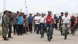 Gubernur DKI Jakarta Anies Baswedan bersepeda di kawasan Pantai Kita dan Pantai Maju, Minggu (23/12). Aksi itu mengawali Peletakkan Batu Pertama Jalur Jalan Sehat dan Sepeda Santai (Jalasena) di pulau reklamasi tersebut. (Liputan6.com/Herman Zakharia)