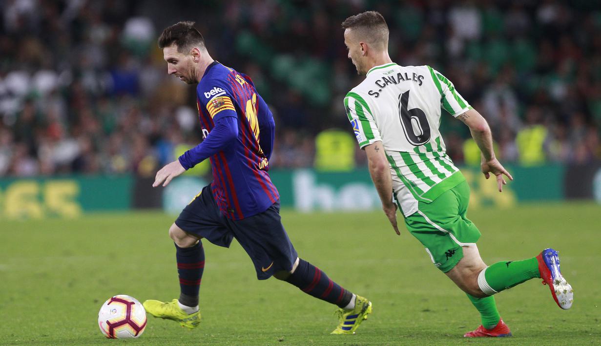 Striker Barcelona, Lionel Messi, berusaha melewati pemain Real Betis, Canales, pada laga La Liga 2019 di Stadion Benito Villamarin, Minggu (17/3). Barcelona menang 4-1 atas Real Betis. (AP/Miguel Morenatti)