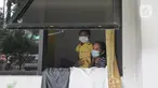 Pasien Covid-19 bersama seorang anak terlihat dari jendela Graha Wisata Ragunan, Jakarta, Selasa (15/6/2021). Pemprov DKI memfungsikan kembali Graha Wisata Ragunan sebagai tempat isolasi warga terpapar COVID-19 kategori OTG sejak pekan lalu dan saat ini merawat 117 pasien. (merdeka.com/Arie Basuki)