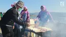 Sejumlah anggota Dharma Wanita Persatuan (DWP) membakar sate dalam memeriahkan Festival Pesona Danau Limboto, Gorontalo, Senin (24/9). MURI mencatat sebanyak 88.950 tusuk sate disajikan secara gratis oleh Pemkab Gorontalo. (Liputan6.com/Arfandi Ibrahim)