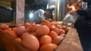 Penjual telur melayani pembeli di Pasar Minggu, Jakarta, Rabu (24/7). Harga telur ayam mengalami penurunan di angka Rp 26 ribu per kilo. (Merdeka.com/Imam Buhori)