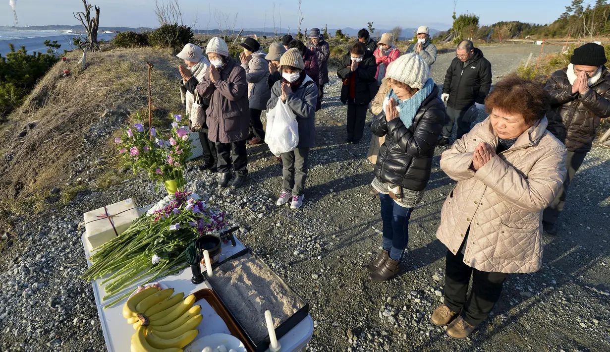 Sejumlah orang berdoa ke arah laut untuk mengenang para korban bencana gempa dahsyat dan tsunami besar di Jepang pada 11 Maret 2011 silam, di Minamisoma, Prefektur Fukushima, Jumat (11/3/2016). (REUTERS/Kyodo)