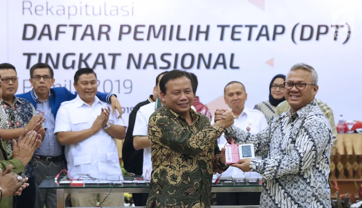 Ketua KPU RI, Arief Budiman (kanan) bersalaman dengan Ketua Bawaslu RI, Abhan saat menyerahkan soft copy DPT tingkat nasional di Jakarta, Rabu (5/9). Sebelumnya, KPU menggelar rapat pleno rekapitulasi DPT nasional. (Liputan6.com/Helmi Fithriansyah)