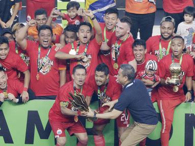 Pemain Persija Jakarta, Ismed Sofyan dan Bambang Pamungkas, mengangkat piala saat selebrasi juara Liga 1 di SUGBK, Jakarta, Minggu (09/12). Persija Jakarta menang 2-1 atas Mitra Kukar. (Bola.com/M Iqbal Ichsan)