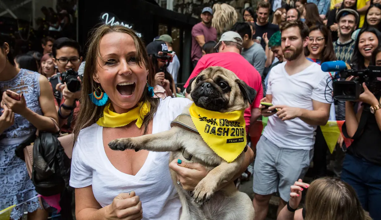 Courtney Terrey berpose dengan anjingnya setelah memenangkan perlombaan di "HK Doggie Dash 2018" di Hong Kong (15/4). Perlombaan ini diadakan untuk mengumpulkan uang bagi anjing yang telah diterlantarkan dan diselamatkan. (AFP Photo/Isaac Lawrence)