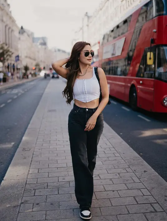 Andi Annisa nikmati liburan rasa warlok di London dengan korset putih dan jeans. Dipadukan dengan snearkes dan shoulder bag [@andiannsyah]