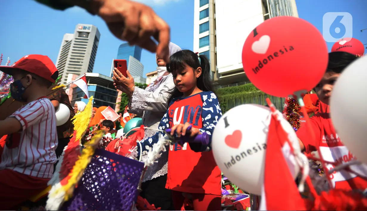 Anak-anak RW 04 Kebun Melati mengikuti karnaval sepeda hias saat pelaksanaan upacara Hari Ulang Tahun ke-77 Republik Indonesia di Jakarta, Rabu (17/8/2022). Peringatan Hari Ulang Tahun Republik Indonesia telah menjadi tradisi di kampung tersebut sejak tahun 1975. (merdeka.com/Imam Buhori)