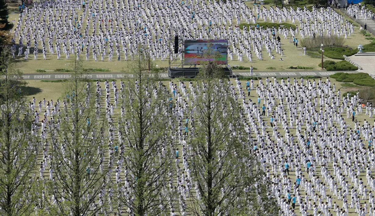 Peserta memperagakan seni bela diri taekwondo di depan Gedung Majelis Nasional Korea Selatan, Seoul, 21 April 2018. Aksi bertajuk "Taekwondo, enunciation of peace" ini merupakan upaya pemecahan rekor Guinness World Records. (AP/Lee Jin-man)