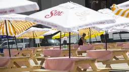 Pelayan membersihkan meja area makan terbuka sebuah restoran di Toronto, Kanada, 18 Juli 2020. Kota Toronto meluncurkan program CafeTO yang memungkinkan restoran dan bar memperluas area makan terbuka mereka guna melayani lebih banyak pelanggan dengan aman selama pandemi COVID-19. (Xinhua/Zou Zheng)