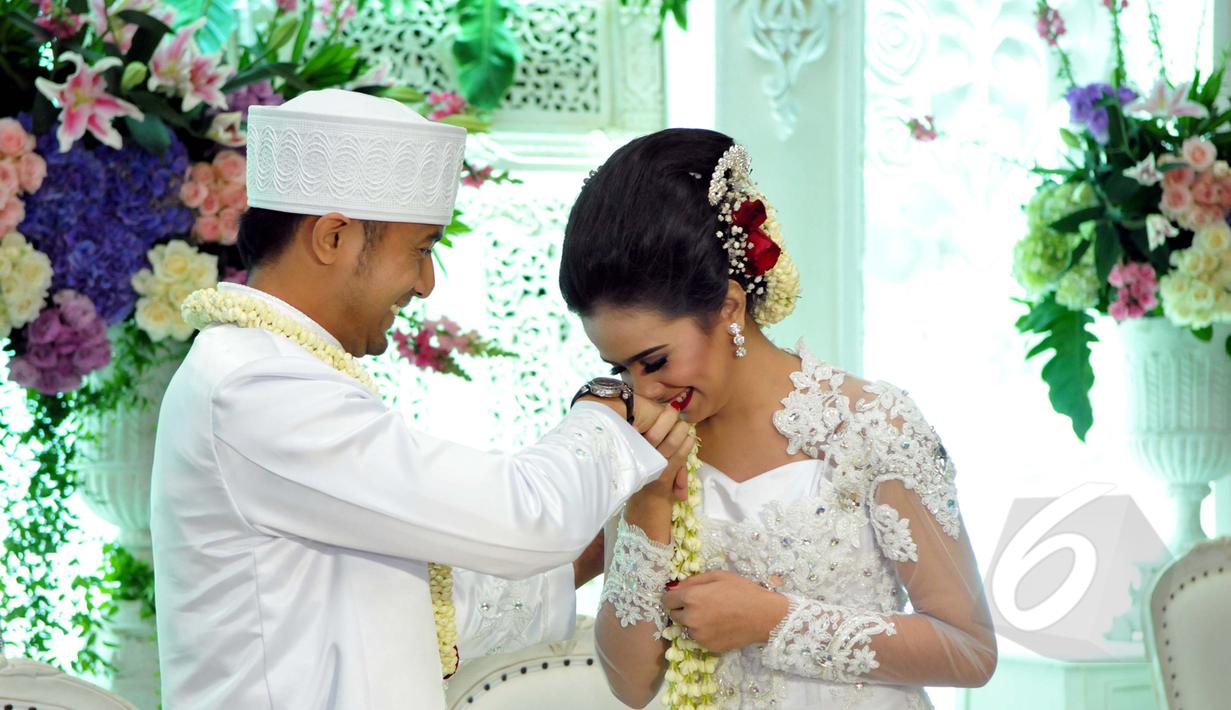 Sonya Fatmala saat mencium tangan Hengky Kurniawan usai melangsungkan akad nikah di sebuah hotel kawasan TMII, Jakarta, Kamis (23/4/2015). (Liputan6.com/Panji Diksana)
