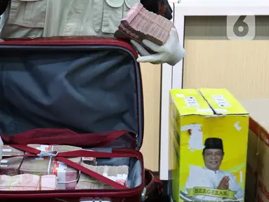 Petugas Komisi Pemberantasan Korupsi (KPK) mengeluarkan uang sitaan hasil Operasi Tangkap Tangan (OTT) di lingkungan Provinsi Kalimantan Selatan di gedung Merah Putih, Jakarta, Selasa (8/10/2024). (Liputan6.com/Herman Zakharia)
