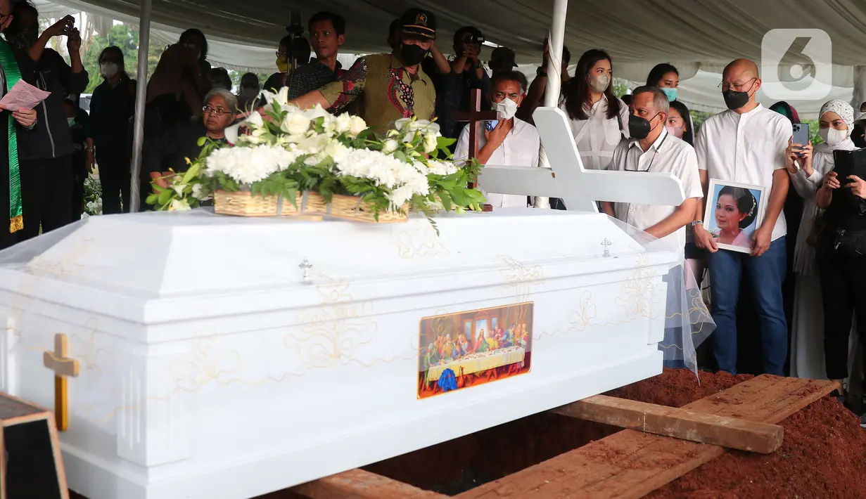 Peti jenazah aktris senior Rima Melati bersiap diturunkan ke liang lahat di TPU Tanah Kusir, Jakarta Selatan, Sabtu (25/6/2022). Rima Melati meninggal dunia pada Kamis (24/6). Sebelum meninggal dia sempat dirawat lantaran komplikasi dan infeksi. (Liputan6.com/Angga Yuniar)