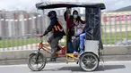 Seorang wanita menggunakan bicitaxis sebagai alternatif transportasi setelah penghancuran beberapa stasiun layanan publik selama protes terhadap pemerintah Presiden Kolombia Ivan Duque, di Bogota (24/5/2021). (AFP/ Raul Arboleda)