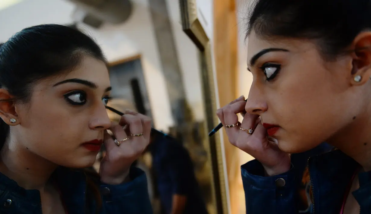 Peserta saat merias wajahnya saat mengikuti audisi model Amazon India Fashion Week 2017 di New Delhi (20/1). Puluhan wanita bersaing untuk dapat terpilih dalam 16 model yang tampil di Amazon India Fashion Week 2017. (AFP Photo)