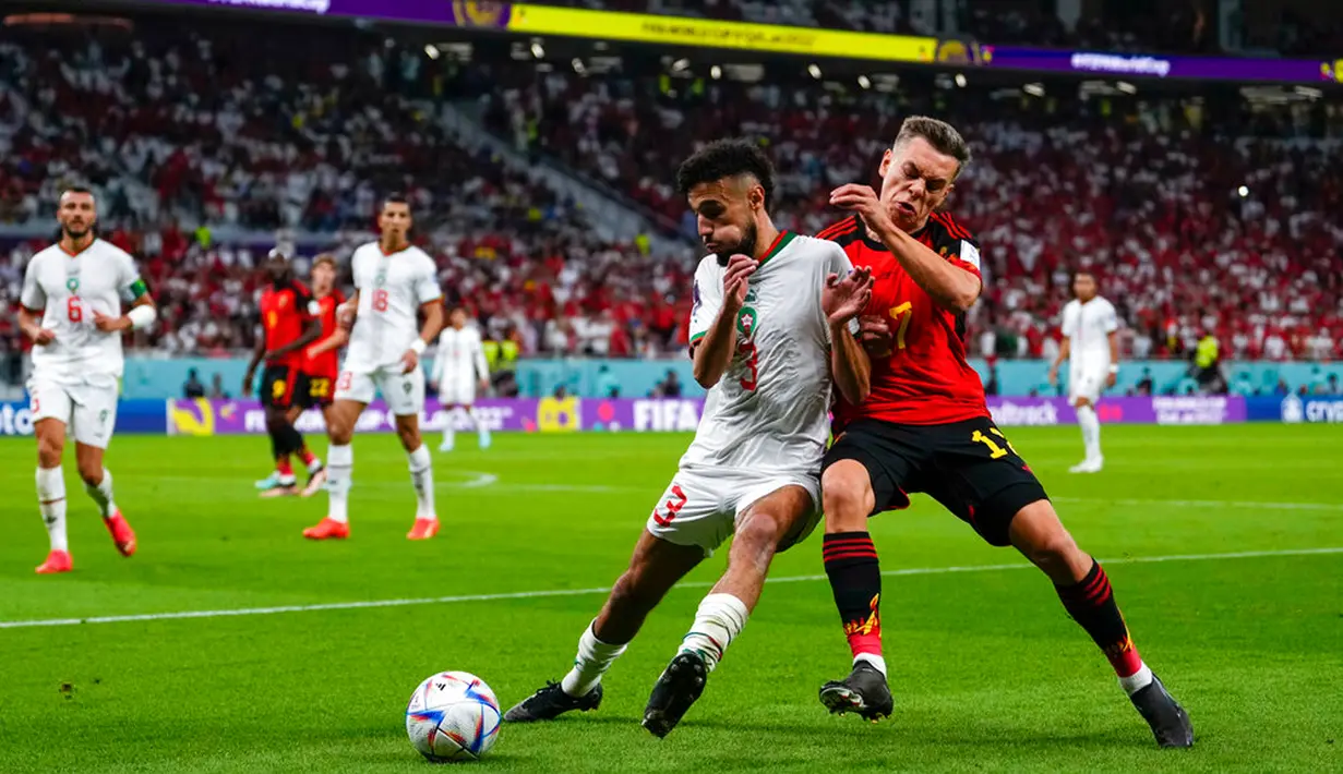 Pemain Belgia Leandro Trossard (kiri) dan pemain Maroko Noussair Mazraoui berebut bola pada pertandingan sepak bola Grup F Piala Dunia 2022 di Stadion Al Thumama, Doha, Qatar, 27 November 2022. Maroko mengalahkan Belgia dengan skor 2-0. (AP Photo/Manu Fernandez)
