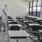 Petugas sekolah menyemprotkan disinfektan di salah satu ruang kelas usai Pembelajaran Tatap Muka (PTM) 100 persen di SMP Negeri 9 Depok, Senin (24/1/2022). Penyemprotan disinfektan juga guna mengantisipasi penyebaran Covid-19 varian Omicron yang terus meningkat. (merdeka.com/Iqbal S Nugroho)