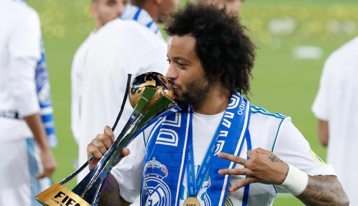 Bek Real Madrid, Marcelo mencium trofi Piala Dunia Antarklub 2017 di stadion Zayed Sports City di Abu Dhabi, Uni Emirat Arab, (16/12). Madrid sukses mengalahkan Gremio 1-0 berkat gol Cristiano Ronaldo. (AP Photo / Hassan Ammar)
