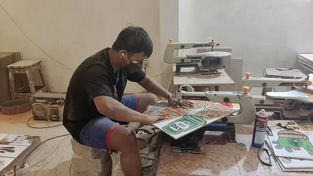 Andyk saat memberikan masukan terkait pewarnaan kepada salah satu pegawai dalam pembuatan handycraft di tempat produksi.