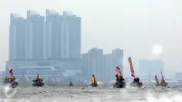 Para nelayan bersama keluarganya berlayar untuk mengikuti sedekah bumi Nadran di Muara Angke, Jakarta, Minggu (13/12). Tradisi ini diikuti ratusan kapal dengan melarung dan memperebutkan sesaji di tengah laut. (Liputan6.com/Helmi Afandi)