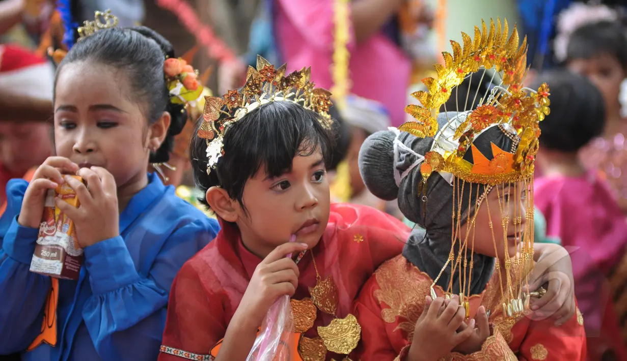 Sejumlah murid TK Sekolah Alternatif untuk Anak Jalanan (SAAJA) tengah minum saat mengikuti pawai dalam rangka peringatan Hari Kartini di kawasan Kuningan, Jakarta, Selasa (21/4/2015). (Liputan6.com/Faizal Fanani)