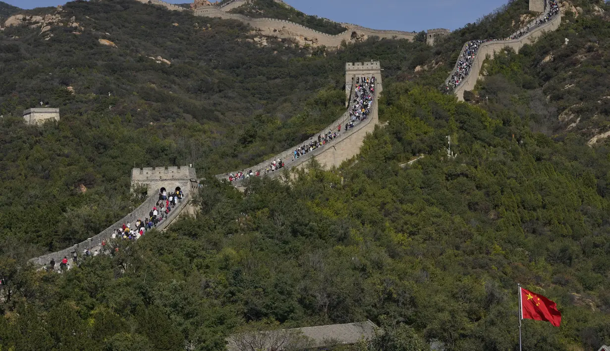 Turis menaiki bentangan Tembok Besar Badaling di pinggiran Beijing, Selasa (6/10/2020). Liburan tahun ini, yang bertepatan dengan Festival Pertengahan Musim Gugur, akan menjadi ujian lakmus apakah industri pariwisata China dapat bangkit kembali setelah digempur oleh COVID-19. (AP Photo/Ng Han Guan)
